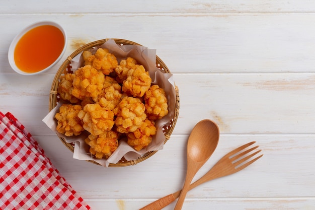 Palline di gamberetti ricoperte di fritto impanato sulla superficie in legno bianco.