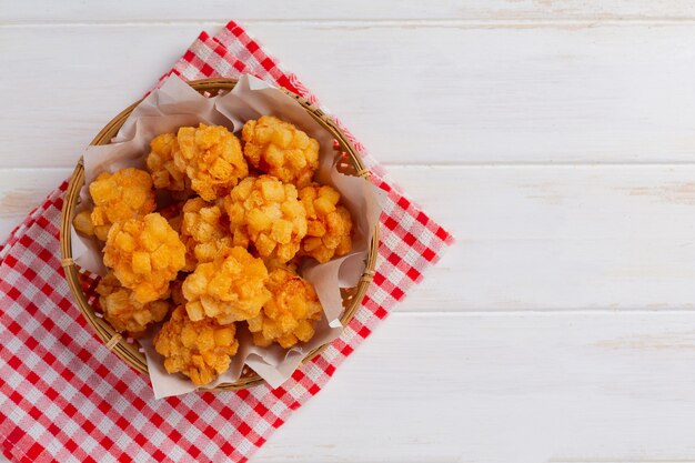 Palline di gamberetti ricoperte di fritto impanato sulla superficie in legno bianco.