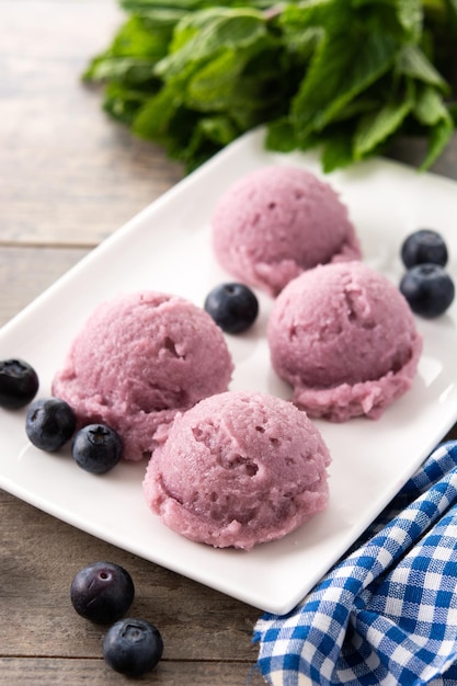 Palline di gelato al mirtillo su tavola di legno