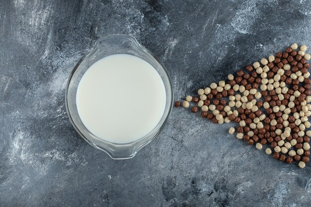 Palline di latte e cereali freschi su marmo.