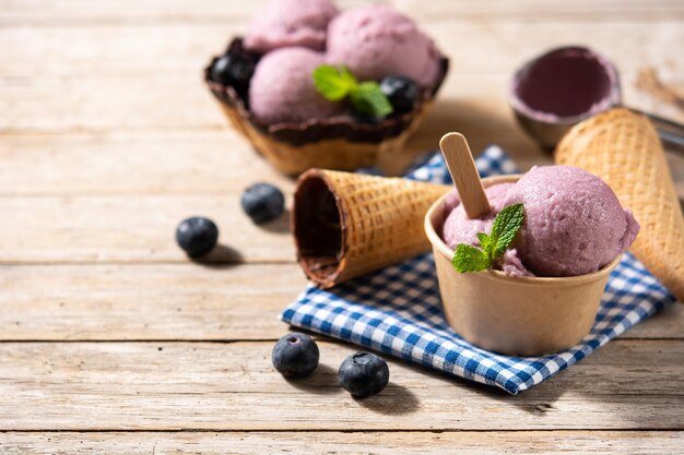 Palline per gelato al mirtillo con cialda sul tavolo di legno