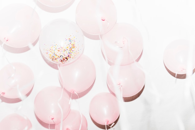 Palloncini bianchi e rosa di compleanno su sfondo bianco