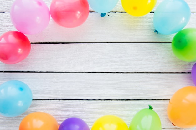 Palloncini colorati decorati sulla plancia di legno bianco