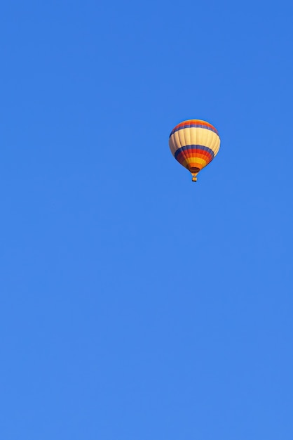 Palloncino multicolore volante nel cielo blu brillante