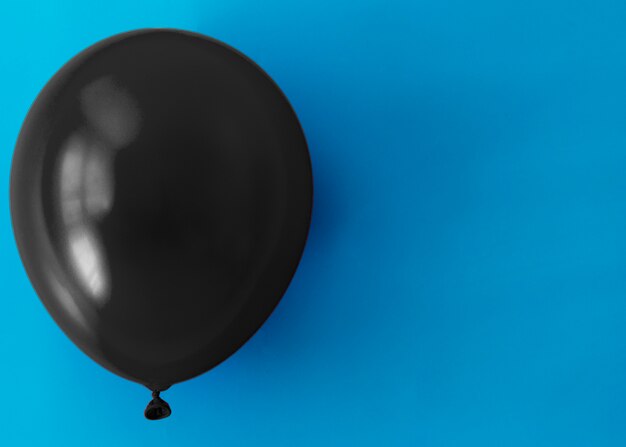 Palloncino nero su sfondo blu con spazio di copia