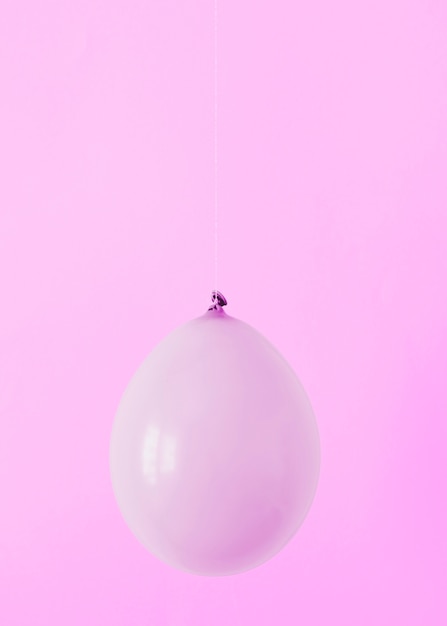 Palloncino viola su sfondo rosa