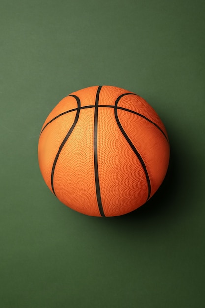 Pallone da basket arancione brillante. Attrezzatura sportiva professionale isolata su priorità bassa verde.
