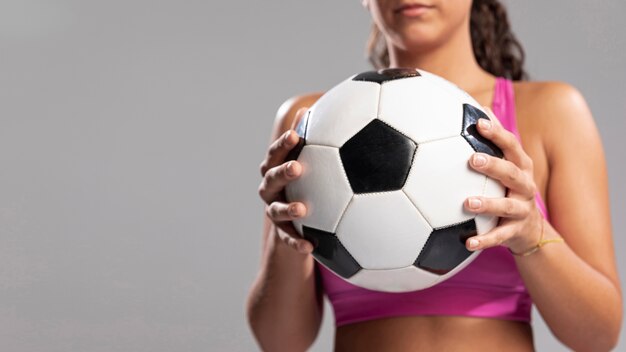 Pallone da calcio della tenuta della donna del primo piano