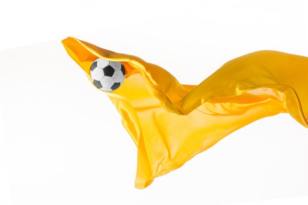 Pallone da calcio e panno giallo trasparente elegante liscio isolato o separato sul fondo bianco dello studio.