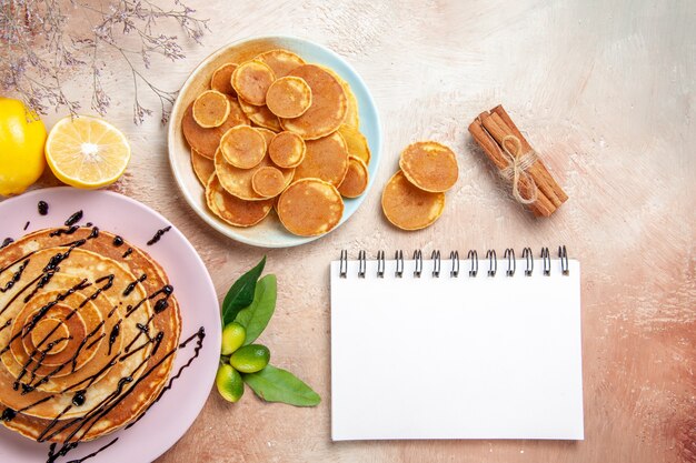 Pancake classici semplici e decorati con frutta e taccuino