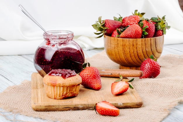 Pancake di vista laterale con la fragola e il coltello freschi dell'inceppamento di fragola su fondo bianco