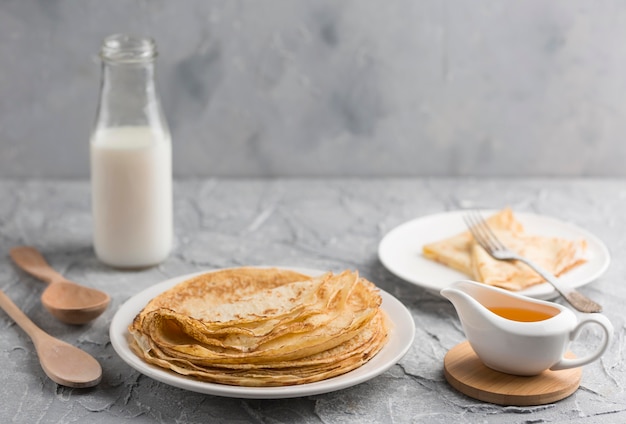 Pancake sul piatto con la bottiglia per il latte