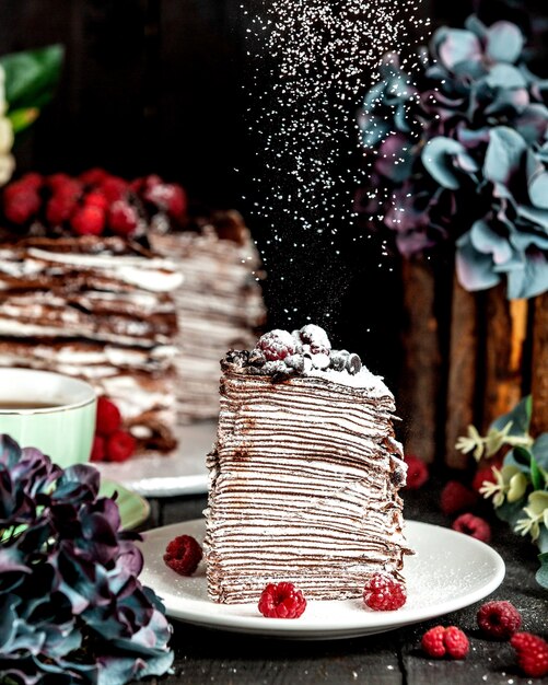 Pancake torta al cioccolato con lamponi cosparsi di zucchero a velo