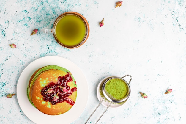 Pancake verdi con polvere di matcha con marmellata rossa, vista dall'alto