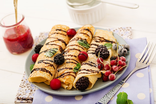 Pancakes con cioccolato, marmellata e frutti di bosco. Gustosa colazione