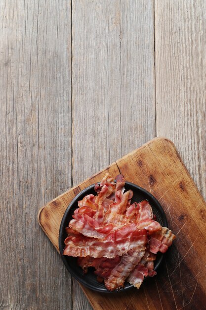 Pancetta fritta su banda nera e tagliere di legno