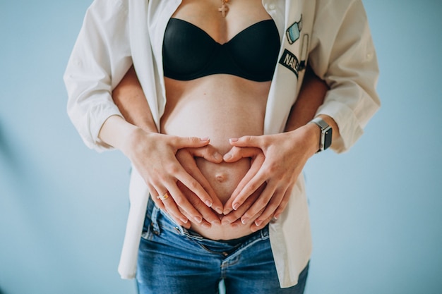 Pancia della holding della donna incinta, del padre e della madre