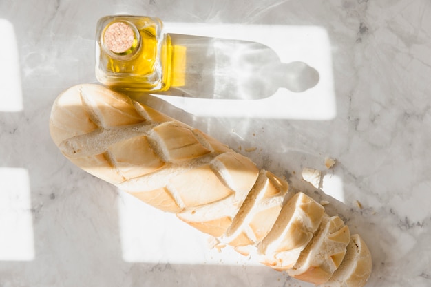 Pane baguette con bottiglia di olio d&#39;oliva sul piano di lavoro della cucina