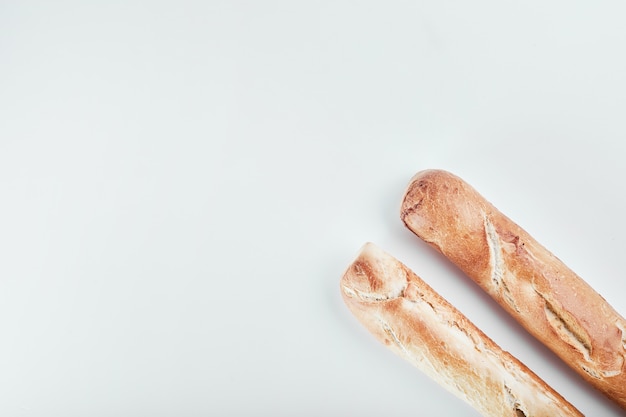 Pane baguette isolato sulla tavola bianca.