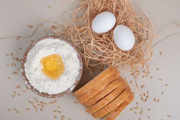 Pane bianco affettato fresco con ciotola di legno piena di farina