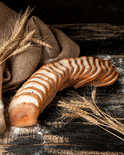 Pane bianco affettato pane bianco con grano e farina sulla tavola