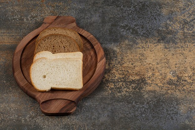 Pane bianco e nero fatto in casa su tavola di legno