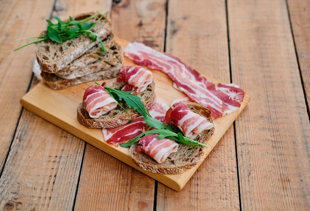 Pane con carne gourmet su una scrivania in legno su sfondo verde prato.