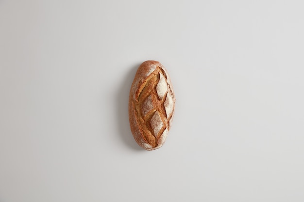 Pane contadino nutriente fatto a mano in casa gustoso sulla superficie bianca. Panetteria e concetto di cibo. Lay piatto. Pane francese a lievitazione. Concetto di nutrizione sana organica. Prodotto naturale dell'azienda agricola, agricoltura