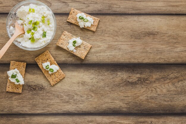 Pane croccante con formaggio cremoso fresco su fondo di legno