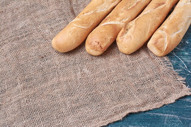 Pane croccante delle baguette sulla tavola blu.