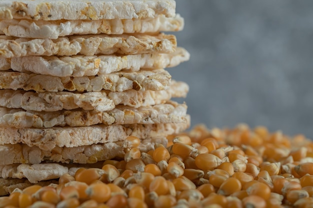 Pane croccante e semi di mais crudo sul pezzo di legno