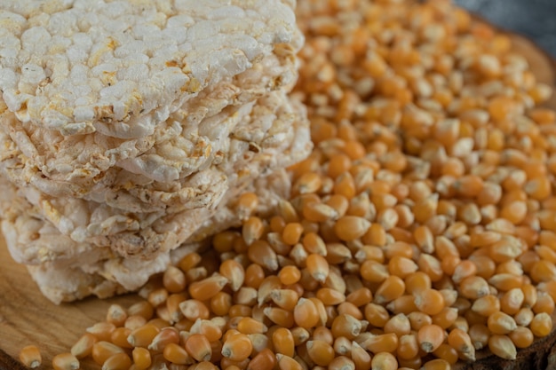 Pane croccante e semi di mais crudo sul pezzo di legno