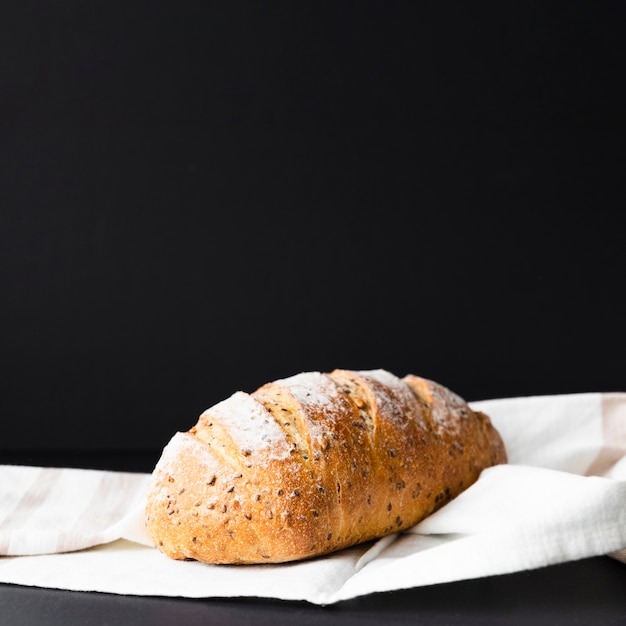 Pane fresco isolato su fondo e panno neri