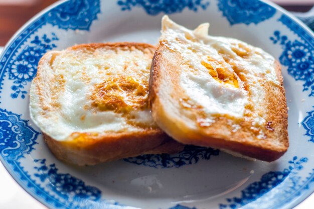 Pane gommoso sul piatto, fotografato con luce naturale. Pane tostato d&#39;oro francese con burro e uovo. Colazione con pane. Colazione inglese. Colazione sana con uova