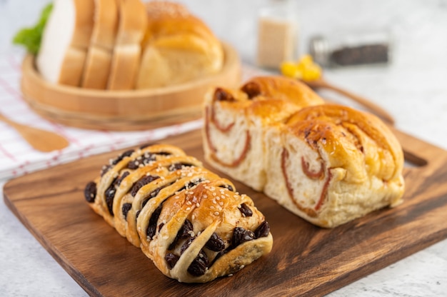 Pane in un vassoio di legno su un panno rosso e bianco.