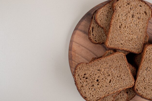 Pane integrale affettato sul piatto di legno. Foto di alta qualità