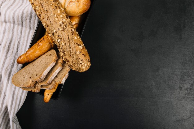 Pane integrale al forno con tovagliolo sul piano di lavoro nero della cucina