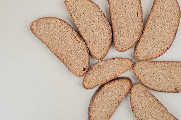 Pane integrale fresco affettato sulla superficie bianca