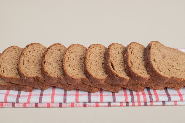 Pane integrale fresco affettato sulla tovaglia