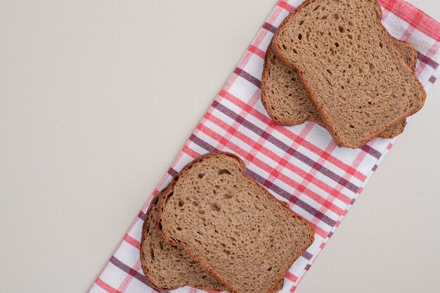 Pane integrale fresco affettato sulla tovaglia