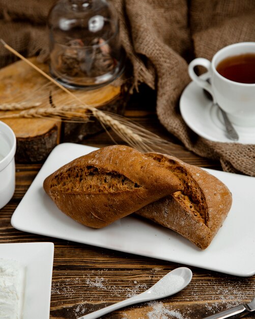 Pane nero fatto di grano su un piatto bianco