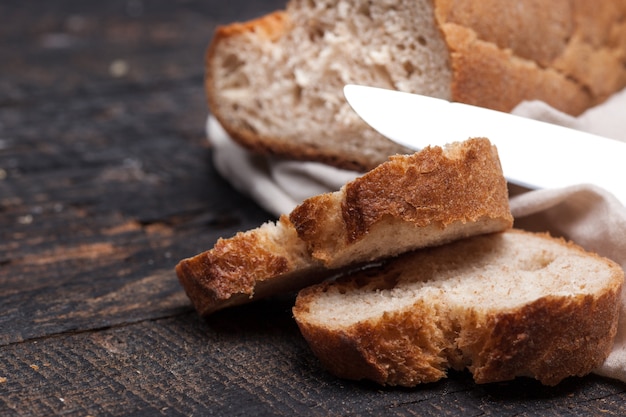 Pane rustico sul tavolo di legno. Sfondo legnoso scuro con spazio di testo libero.