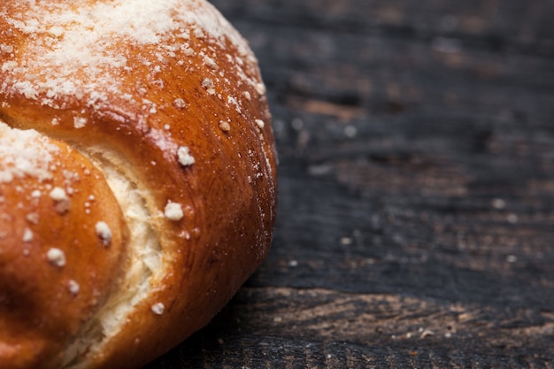 Pane rustico sul tavolo di legno. Sfondo legnoso scuro con spazio di testo libero.