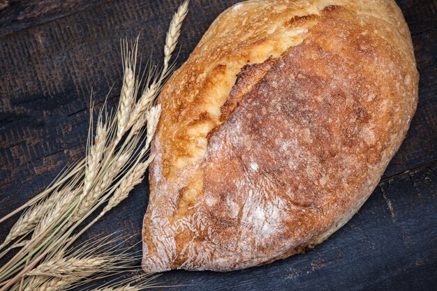 Pane rustico sul tavolo di legno. Spazio oscuro lunatico con spazio di testo libero.