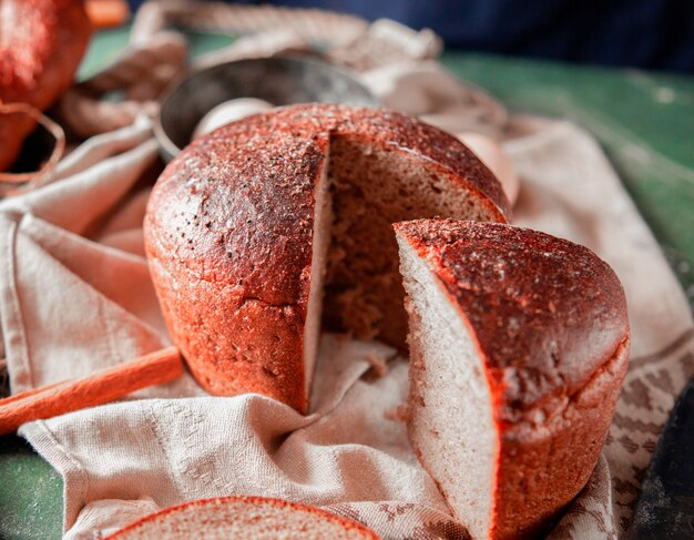 Pane sano rotondo affettato su una tovaglia bianca con cannella intorno.