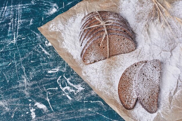 Pane scuro legato con filo rustico sulla tavola blu.