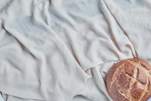 Pane tondo fatto a mano su una tovaglia bianca.