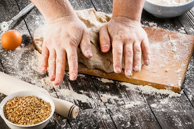 Panettiere che produce pasta di pane con farina di frumento