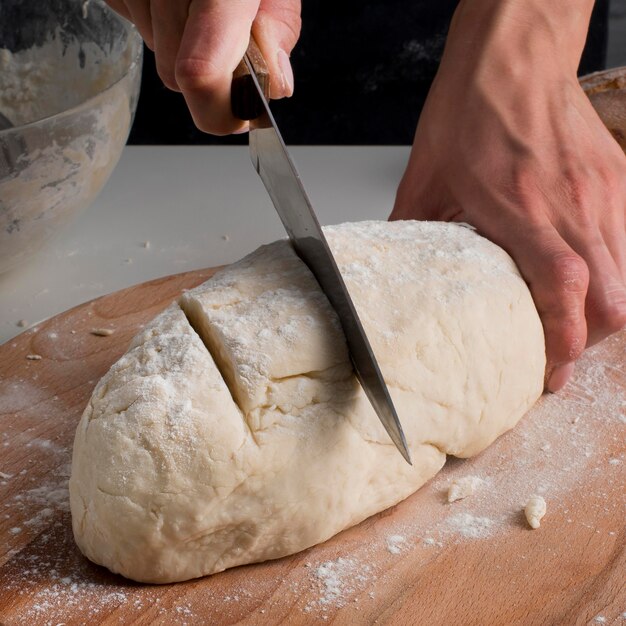 Panettiere del primo piano che affetta pasta