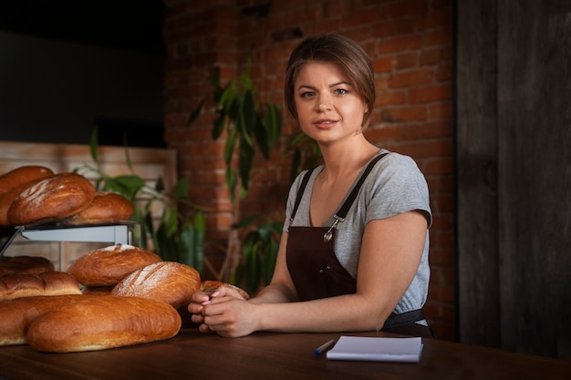 Panettiere femminile che prende appunti mentre si trova in pasticceria